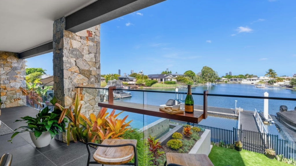 Australian-made Bench Bar clipped to a balcony railing overlooking the water, holding drinks for outdoor entertaining